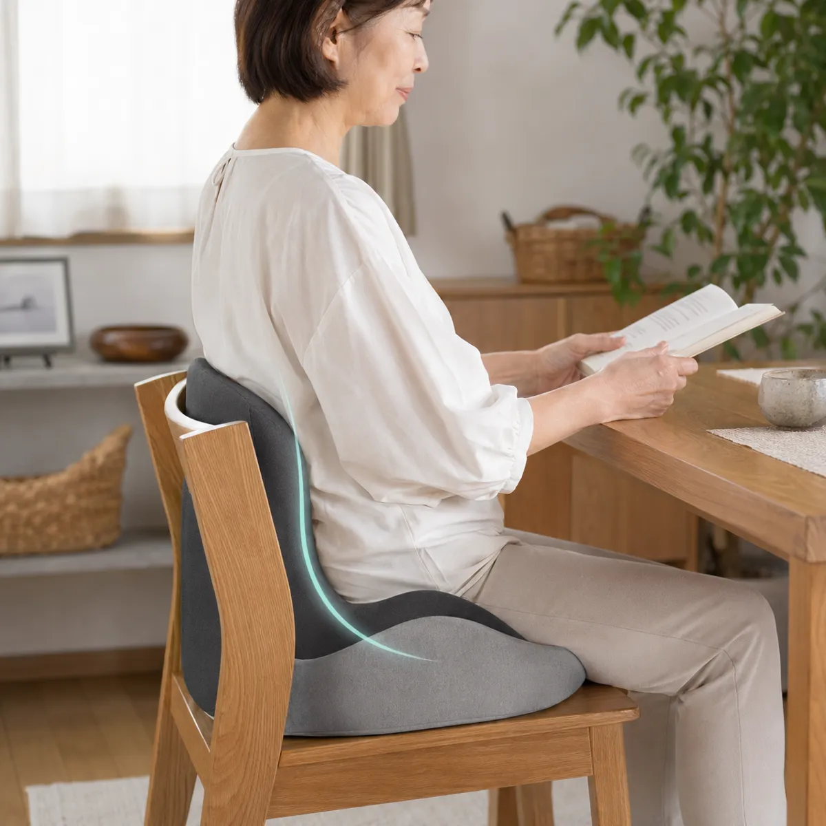 ダイニングチェアでErgoCloudを使い、本を読むシニア女性